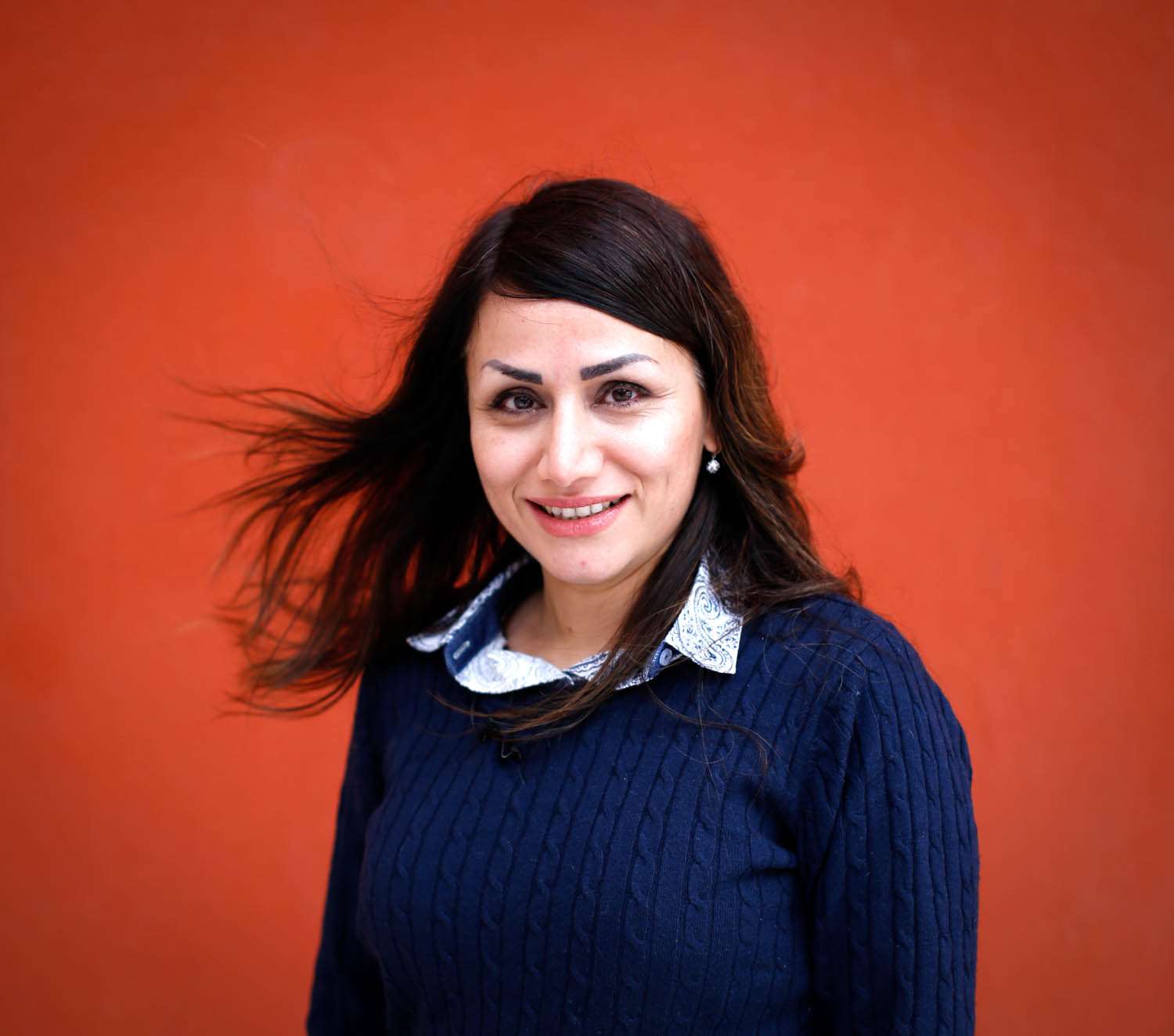 Fereshteh foran en rød vegg